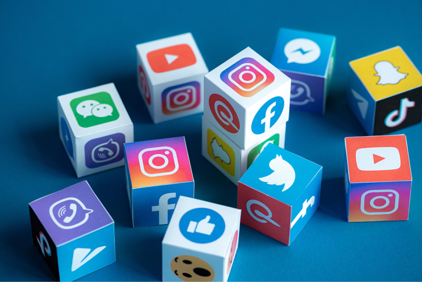 Cubes with social media logos and icons on them. Including Twitter, Facebook, Instagram, Youtube, Pinterest, Snapchat, TikTok, and Messenger.